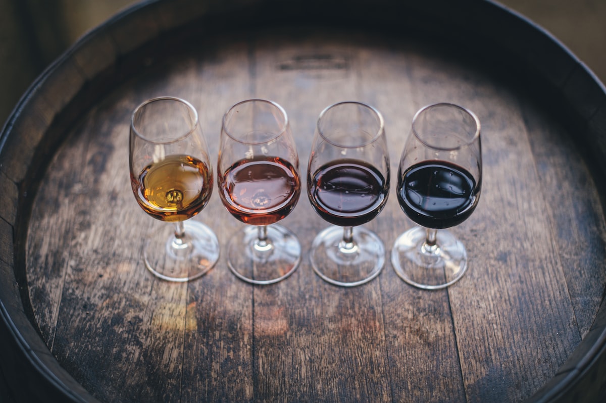 Four wine flight glasses on an oak barrel